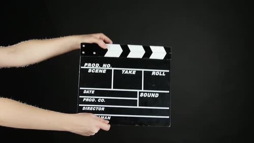 Hands with Movie Production Clapper Board, auf Schwarz, Zeitlupe