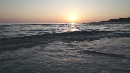 Gentle Waves at Sunset on a Sandy Beach