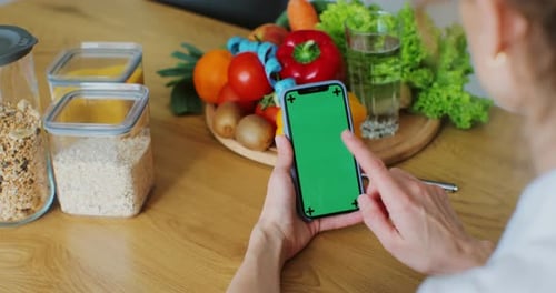 Nutritionist Woman with Healthy Fruit and Vegetable Using Smartphone with Green Screen