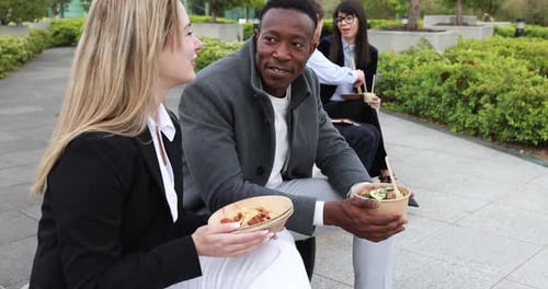 Multiracial business people doing lunch break outdoor from office building