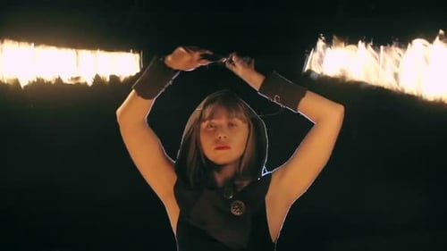 Woman Fire Dancing at Night with Lit Batons