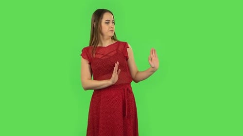 Tender Girl in Red Dress Strictly Gesturing with Hands Shape Meaning Denial Saying NO. Green Screen