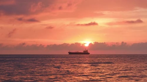Against the background of the sea, the sun goes down, blue and orange clouds flow in sky. time lapse