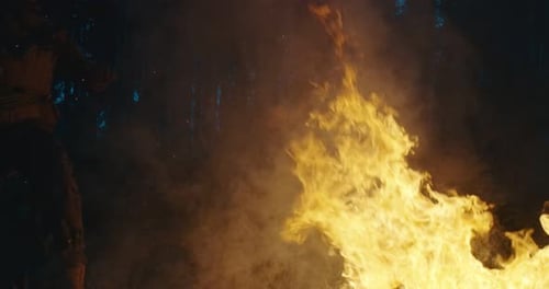Des militaires passent à l'action et sautent par-dessus le feu dans une forêt dense la nuit Concept de