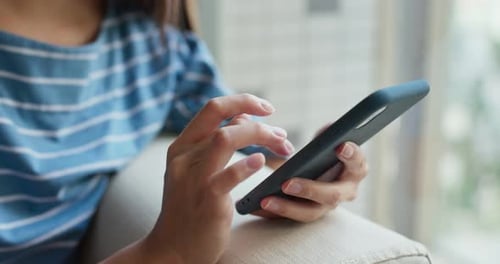 Woman Scrolling on Cell Phone in Home Close Up