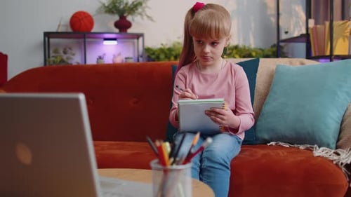 Girl Writes in Notebook While Studying at Home