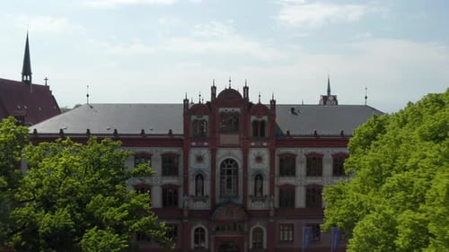 Backwards Rising Reveal of Grown Trees on Small Square in Front of Historical University Building
