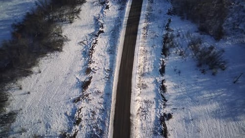 Vista aérea de una carretera asfaltada rodeada de nieve