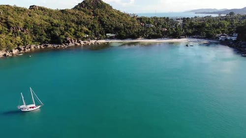 Boat Near Tropical Shore. Amazing Drone View of Modern Yacht Sailing on Calm Sea Water Near Coast
