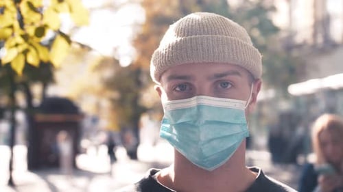 Close Up of Face of Young Caucasian Handsome Man in Medical Mask Looking Straight To Camera