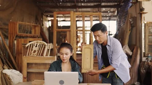 Two asian carpenters in a construction workshop. business man and woman working together