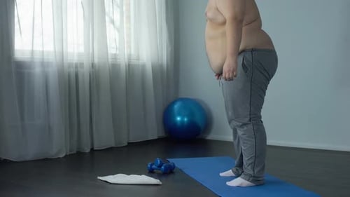 Man Doing Squats on Exercise Mat Indoors