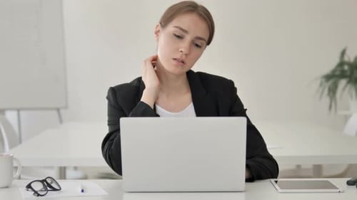Woman Working at Computer Stretches Neck