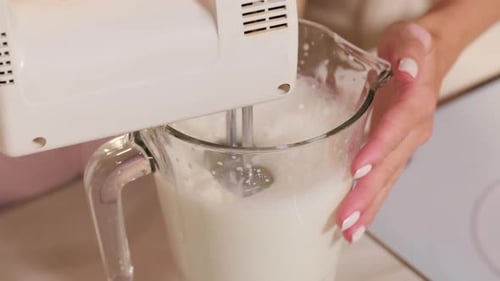Electric Mixer Beats Liquid in Glass Pitcher