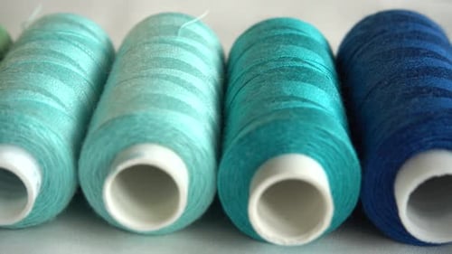 Top view of colorful thread spools isolated on white background.