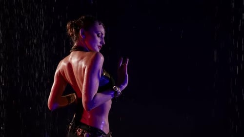Woman Dances in the Rain in a Dark Studio