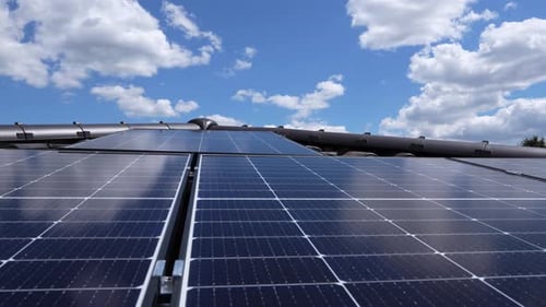 Bright Solar Panels Reflecting Blue Sky Clouds