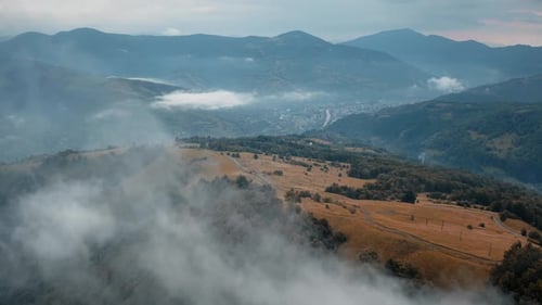 Drone Flying Through Morning Fog Mountain Range in Background