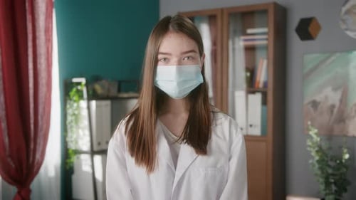 Teen in Mask and White Coat Looks On