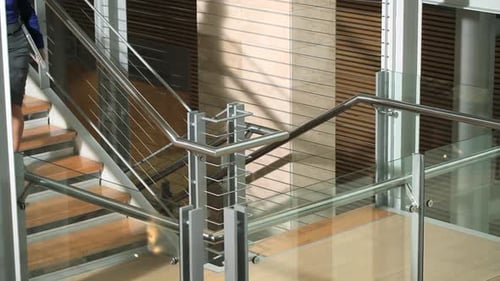 Businesswoman Walking Down Modern Office Staircase