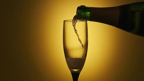 Champagne Pouring in Glass at Yellow Background