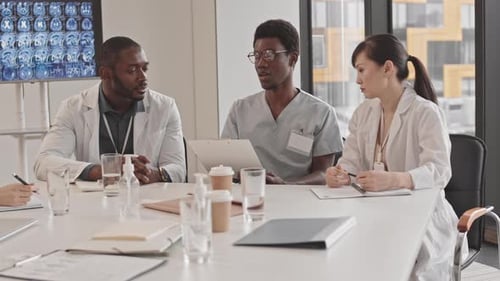 Medical Professionals Meeting Around Table in Modern Office
