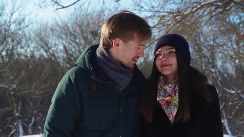 Happy Couple Walking In Winter Forest Playing And Throwing Snow