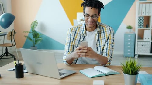 Happy Afro-American Man Employee Using Smartphone Touching Screen in Office