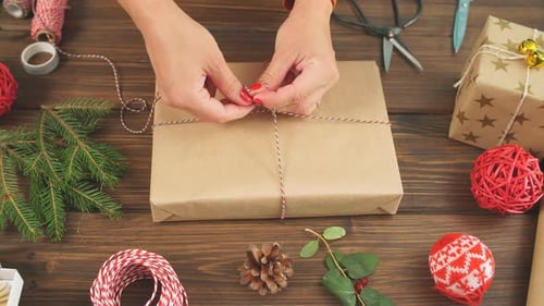 Woman Wrapping Present on Rustic Table Overhead Shot