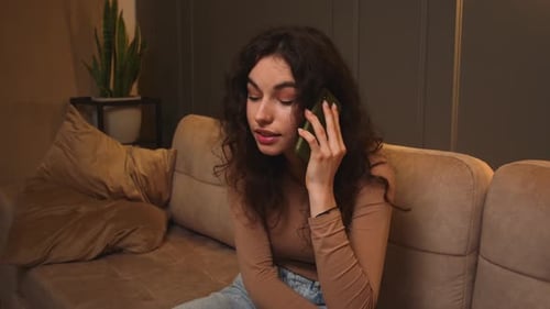 Woman Talking on Smartphone while Sitting on Couch