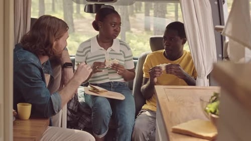 Diverse Friends Eating Sandwiches and Talking in House on Wheels