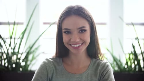 Smiling Brunette Woman in Gray Shirt Close Up