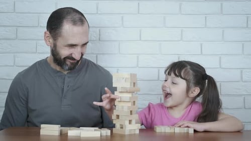Ein Mann mit einem Kind spielt Holzklötze.