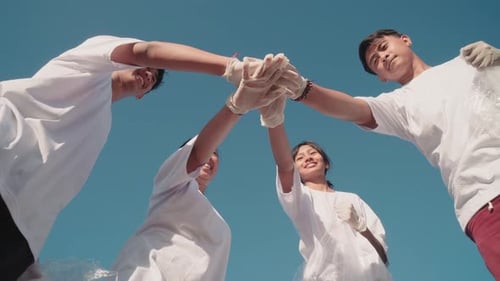 Happy Group Joining Hands to Clean Environment Together