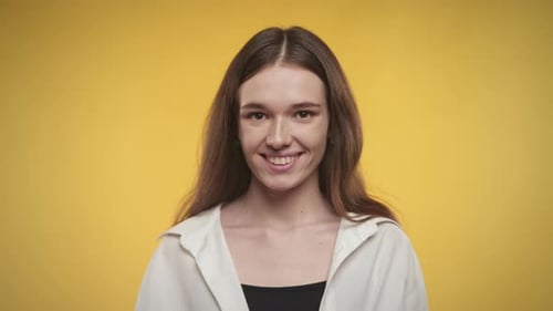 Close Up Portrait of a 20s Young Adult Woman in a White Shirt on a Bright Yellow Background