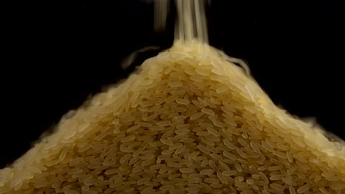 Pouring rice on a black background.