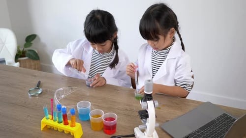 lovely sisters enjoy experimenting with liquids in science class
