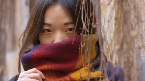 beautiful Chinese woman hidden by the scarf smiles- close up