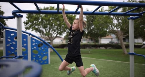 Child Hanging From Monkey Bars on Playground