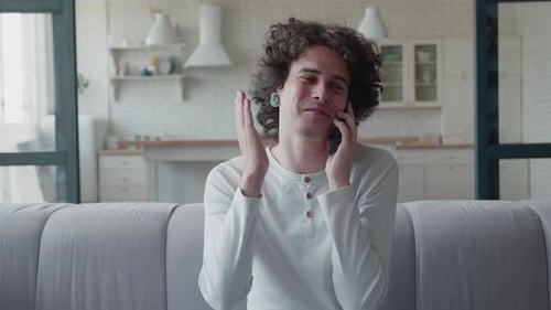 Smiling Young Adult Talking on Cellphone Indoors