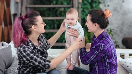 Two Women Playing With a Baby Indoors