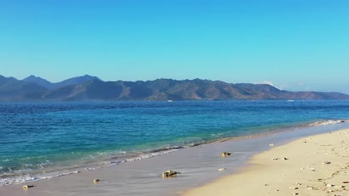 Wide above copy space shot of a paradise sunny white sand beach and blue ocean background in 4K