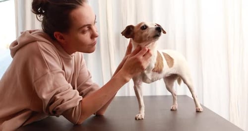 Woman Affectionately Pets Her Dog Indoors