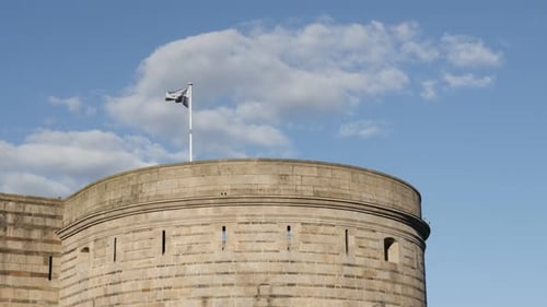 Flag Waving Atop a Stone Tower