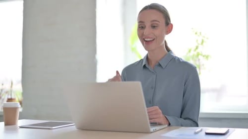 Woman Talking on Video Call on Laptop in Office