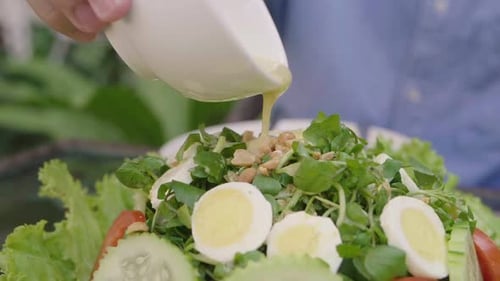 Pouring Dressing Over Fresh, Healthy Salad