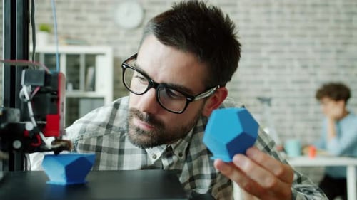Male Researcher Watching 3D Printer Making Plastic Detail Enjoying Process