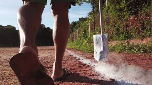 Man Lines Dirt Soccer Field with Powder