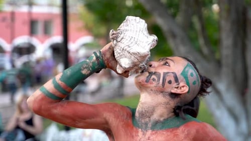 Gros plan extrême d'une danseuse maya ou aztèque jouant d'une conque lors d'un spectacle de danse sacrée.