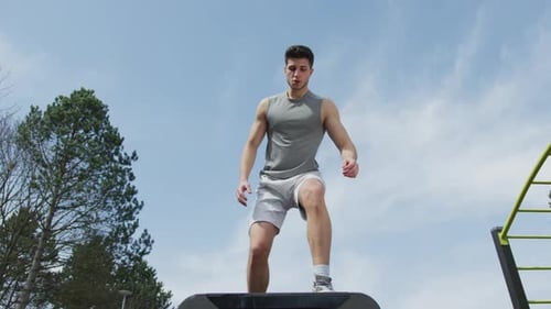 Athletic man doing a box jump